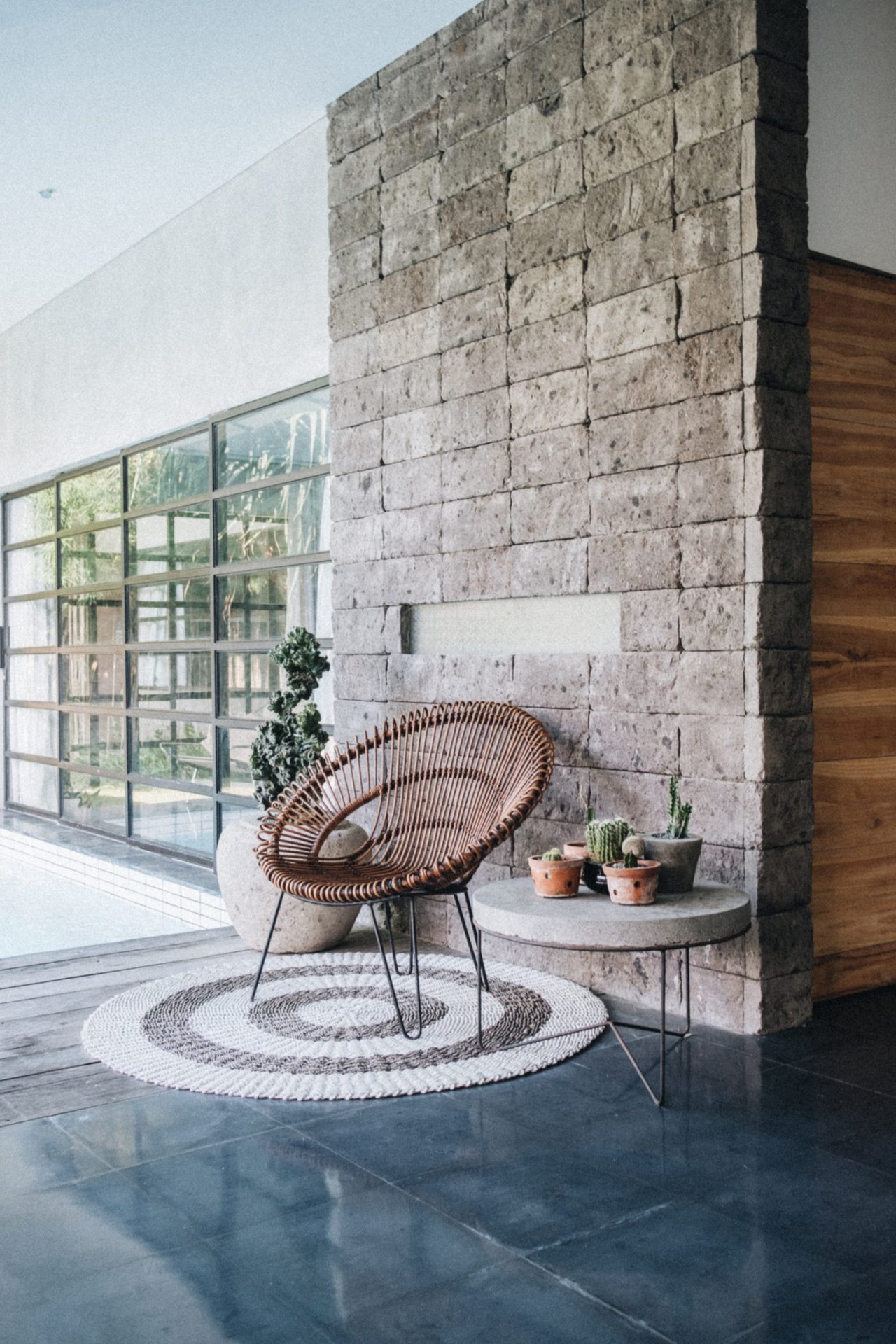 Mid-century home with rattan chair near a stone wall