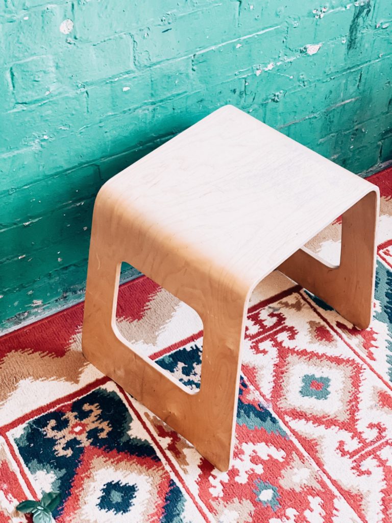 Bright tribal rug with deep green accent wall