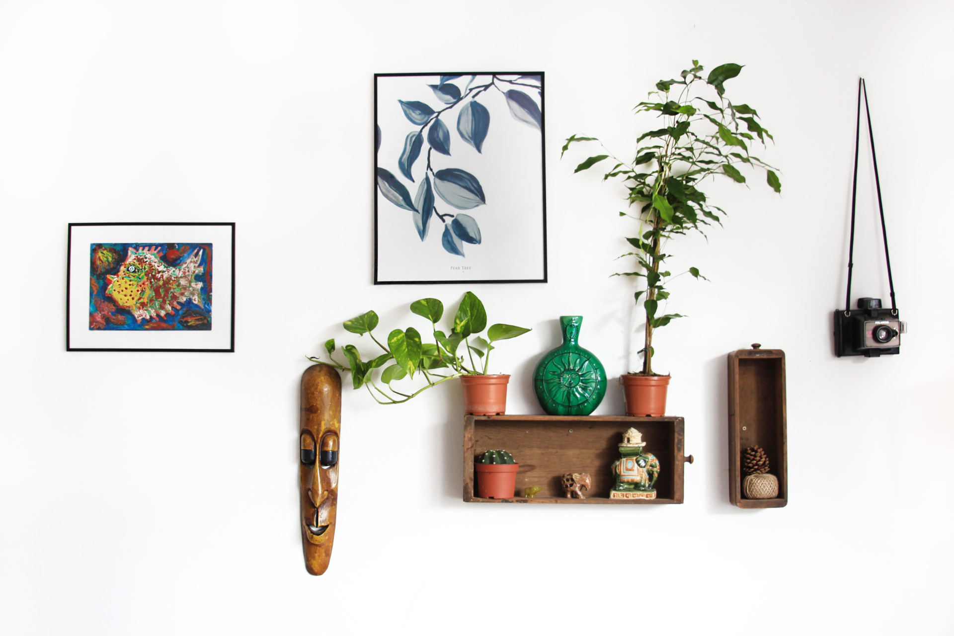 A boho style living room wall with thrifted and antique pieces, handcrafted accessories and cultural artifacts