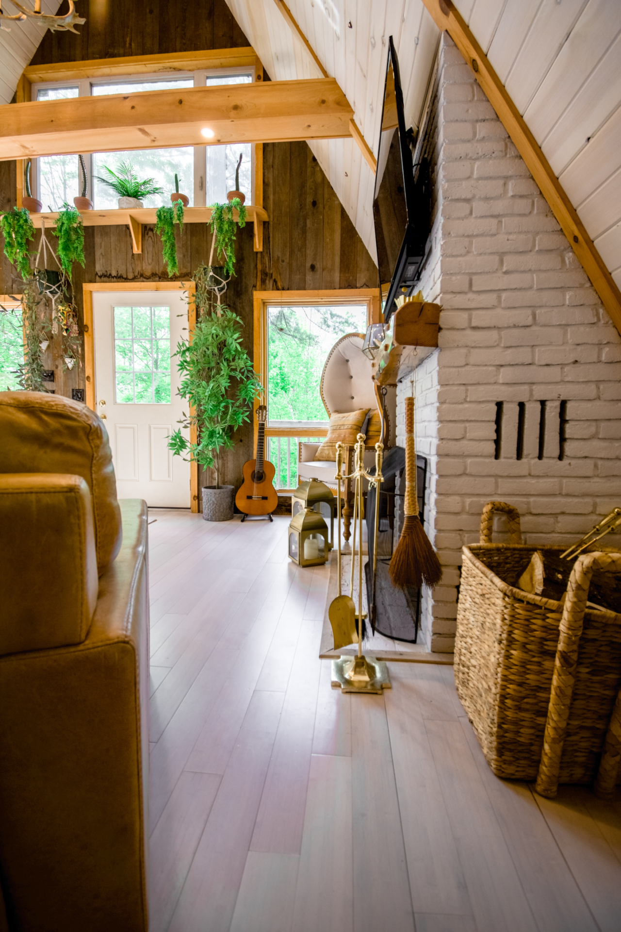 A boho style living room with wood and rattan furniture, jute and sisal textiles and indoor greenery