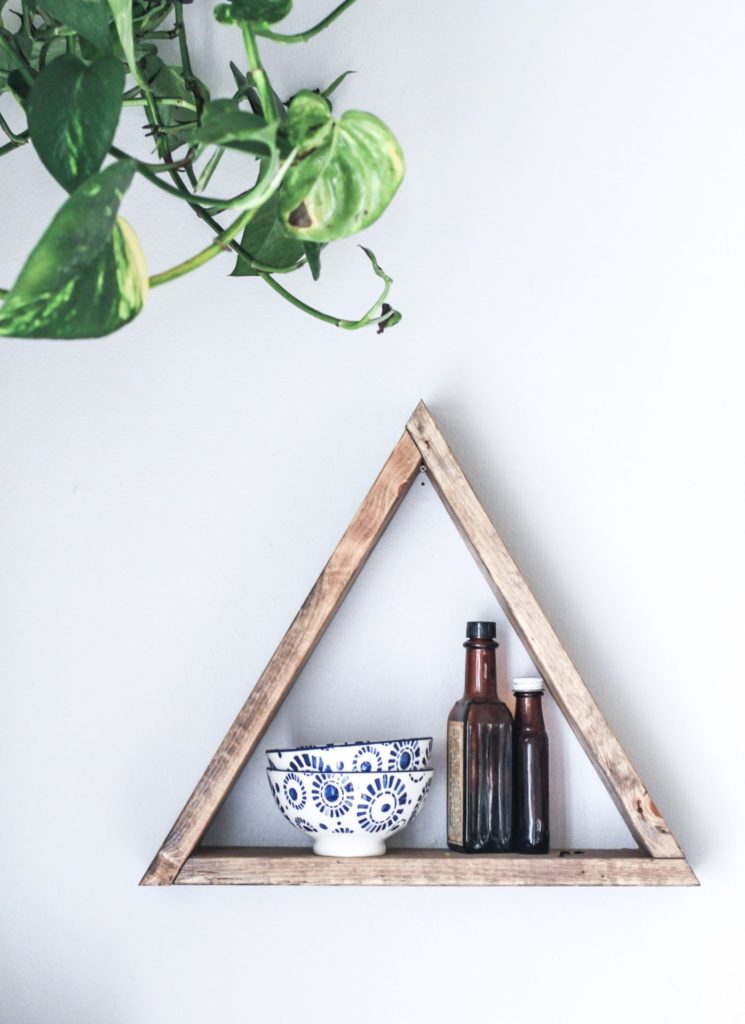 Wood triangle with bowls and plant on wall