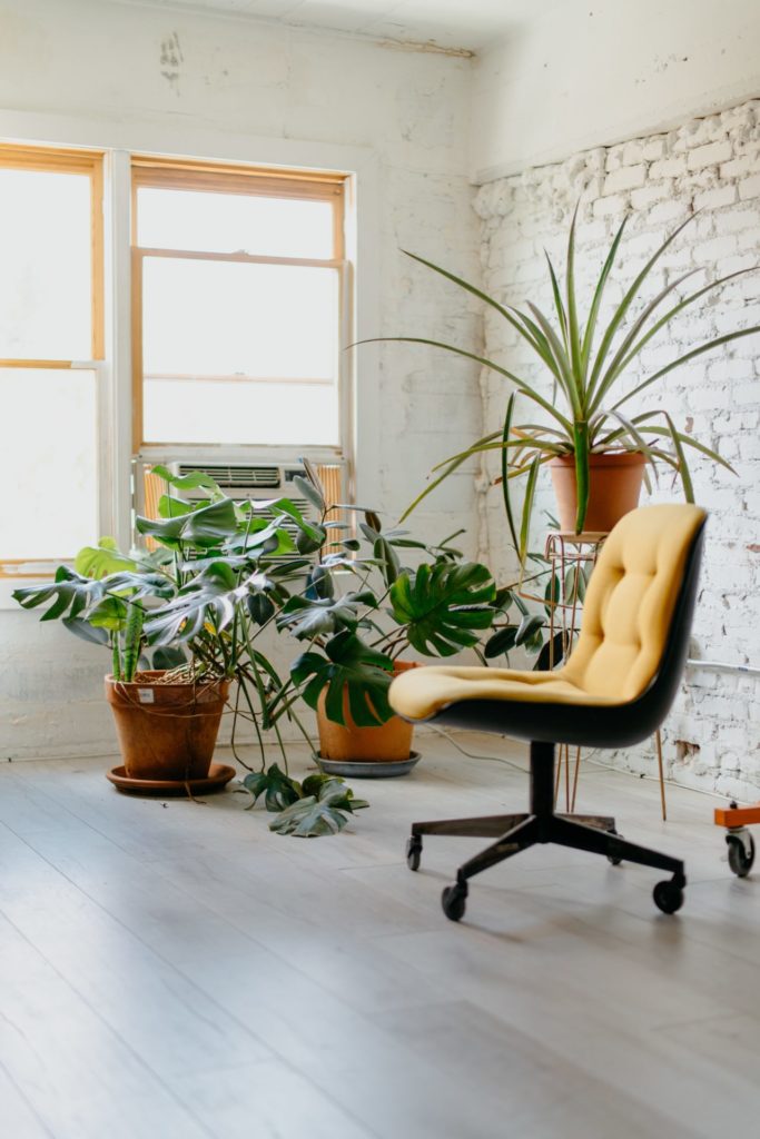 Boho office space with mustard yellow chair and plants